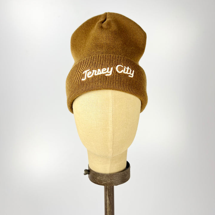Acme brown knit cuffed beanie on mannequin with white Jersey City embroidered beanie script on cuff
