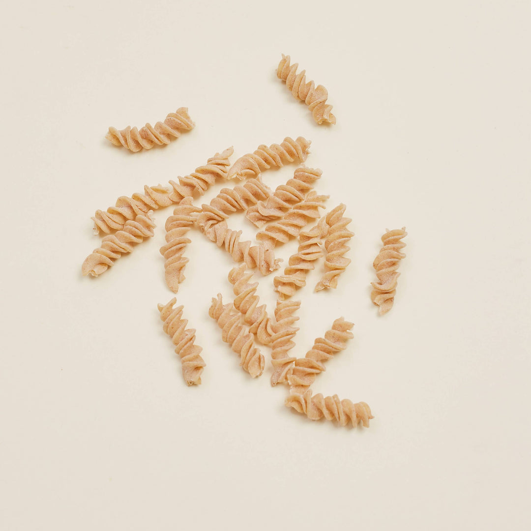 Dried fusilli pasta on a beige background