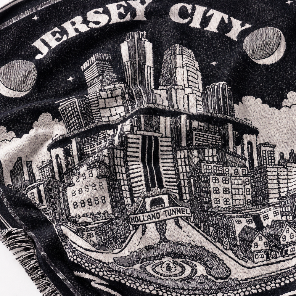 Embroidered design of Jersey City with buildings and 'Holland Tunnel' text on a black background.