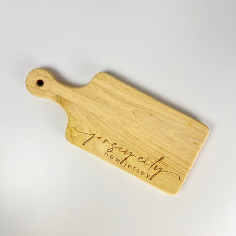 Wooden cutting board with 'Jersey City' engraving on a white background