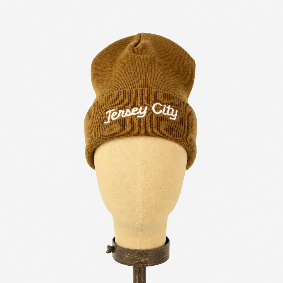 Brown beanie with 'Jersey City' text on a mannequin head against a white background