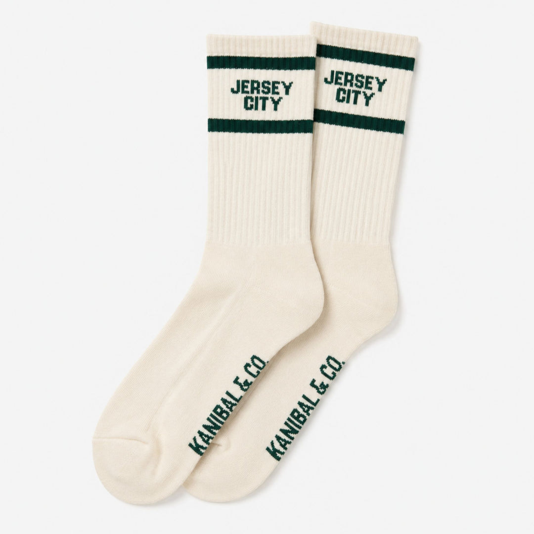 Pair of cream socks with green stripes and text on a white background