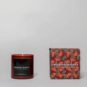 Red glass candle next to packaging with rosemary & blood orange printed on it