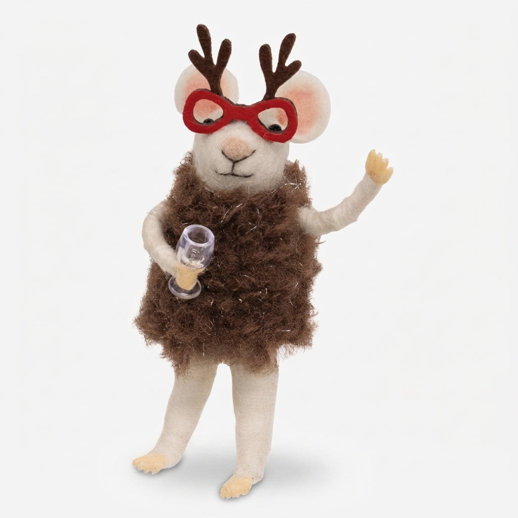 A plush felt animal doll shaped like a small deer or mouse with brown antlers, red glasses, a fuzzy brown body, and cream-colored legs, holding a small clear glass with amber liquid against a light gray background.