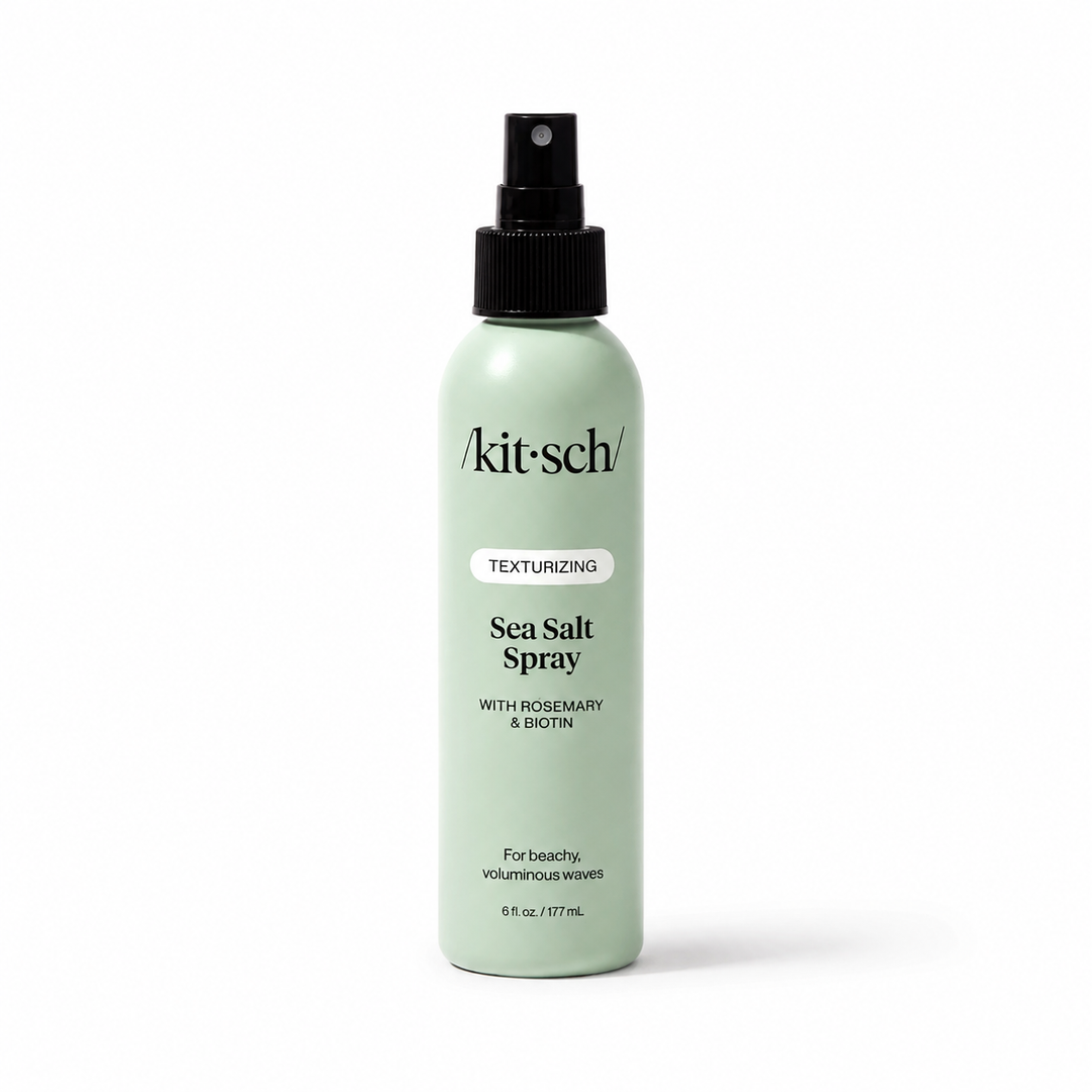 A light mint green bottle of Akit Sch Sea Salt Spray with a black spray nozzle, shown on a clean white background.