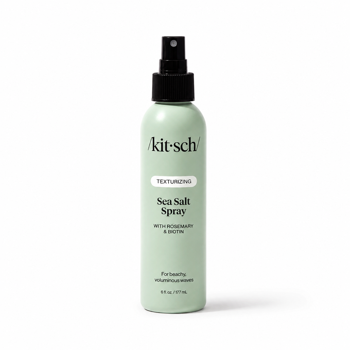 A light mint green bottle of Akit Sch Sea Salt Spray with a black spray nozzle, shown on a clean white background.