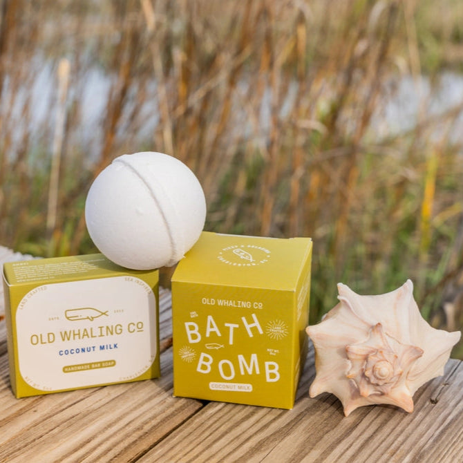 Bath bomb and Old Whaling Co packaging on a wooden surface with a shell and natural background