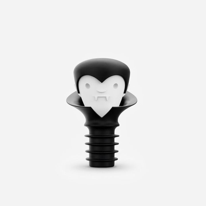 A black plastic bottle stopper shaped like a vampire head with a white heart-shaped face, centered on a light gray background.