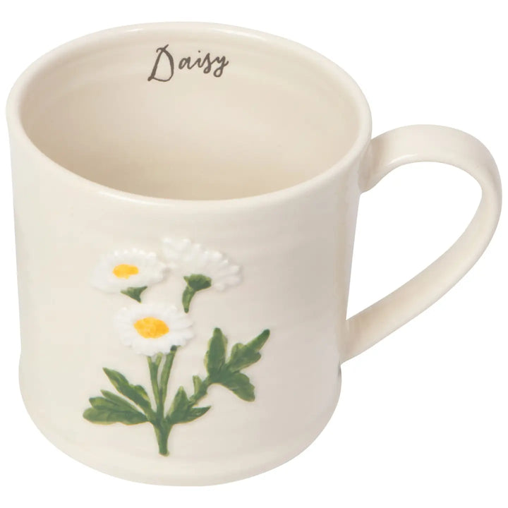 Danica embossed daisy mug featuring a floral design and the word Daisy on a cream-colored background