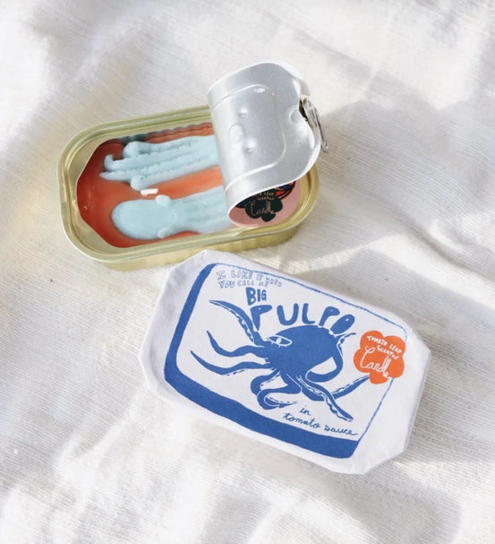 A candle meant to look like two octopi in a fish tin