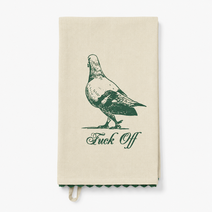 An off-white kitchen tea towel with a dark green sketch of a pigeon and the text 'Fuck Off' printed below it, shown against a plain white background.