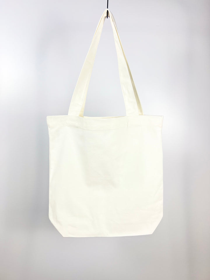 Kanibal Co. plain white Garden State tote bag with long handles hanging on a hook