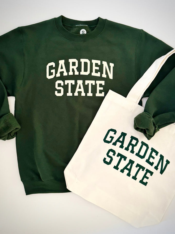Garden State tote bag in white canvas with dark green text paired with a matching dark green sweatshirt