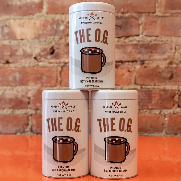 Three cans of Hudson Valley hot chocolate mix labeled The O.G. in premium quality