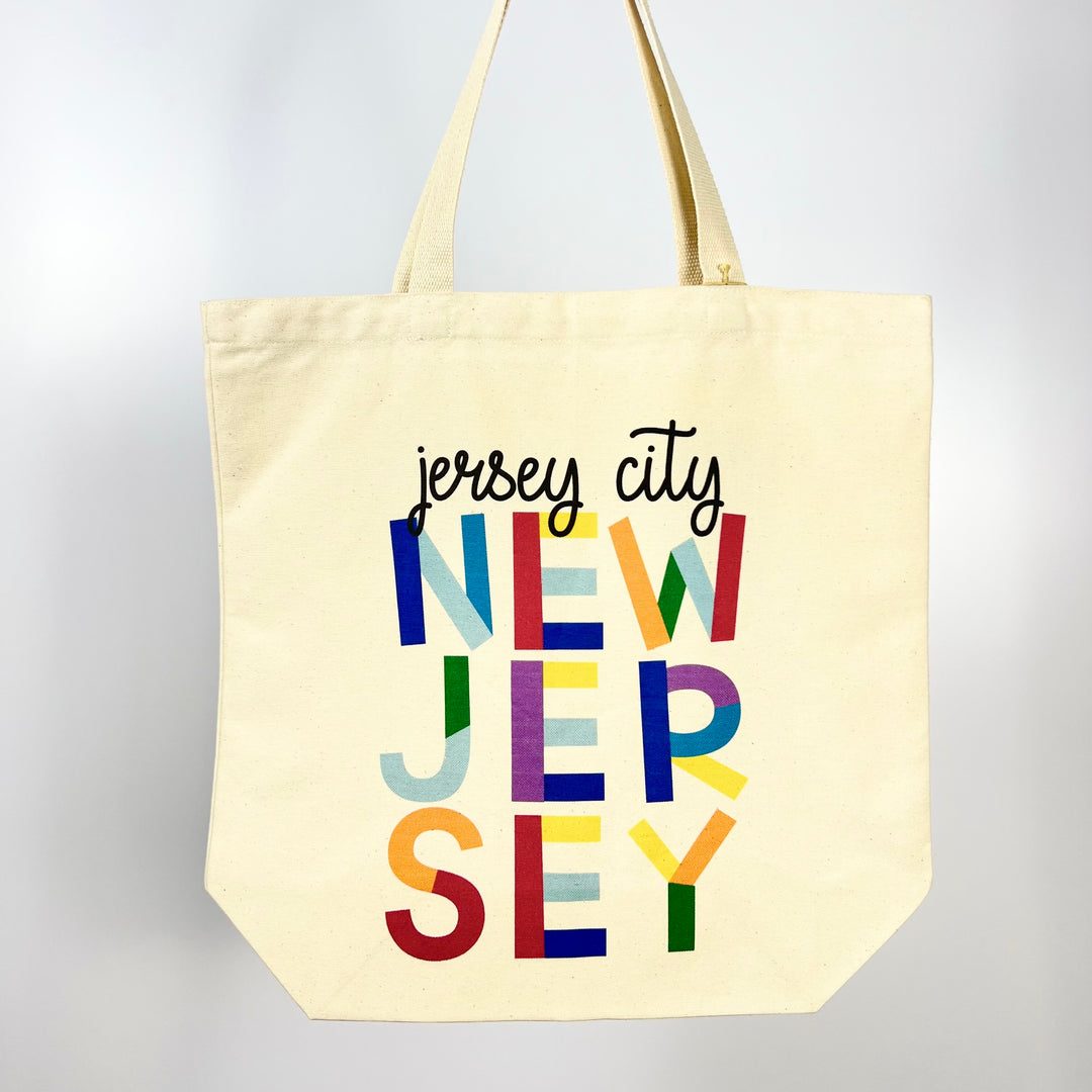 Morado Designs Jersey City tote bag with colorful New Jersey text on natural canvas fabric