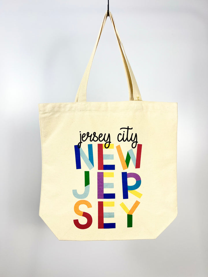 Morado Designs beige Jersey City tote bag with colorful New Jersey text print and shoulder straps
