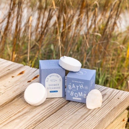Old Whaling Co coastal calm shower steamers with white round steamers and seashell on wooden boardwalk