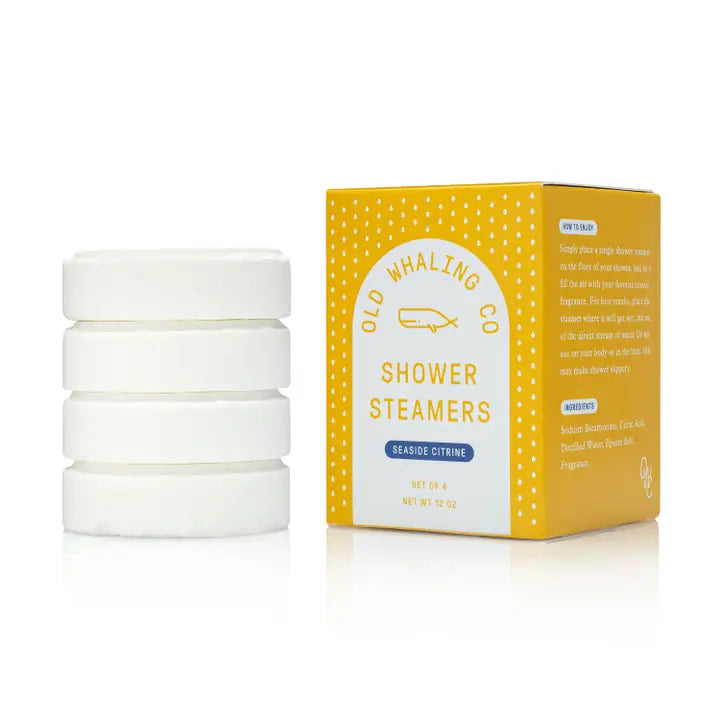 Old Whaling Co seaside citrine shower steamers yellow box beside four stacked white round steamers for refreshing showers