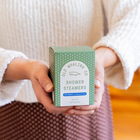 Old Whaling Co spearmint eucalyptus shower steamers boxed set held in hands with green polka dot packaging