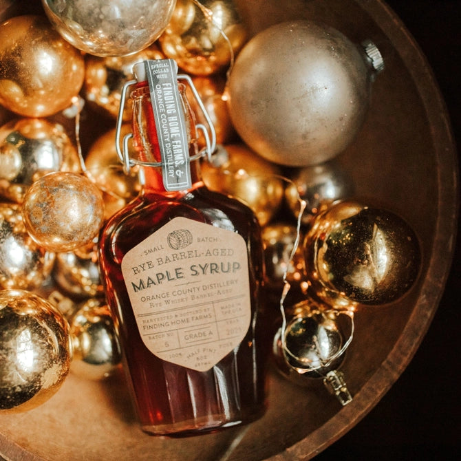 Rye barrel aged maple syrup in a decorative bottle with golden ornaments for festive occasions