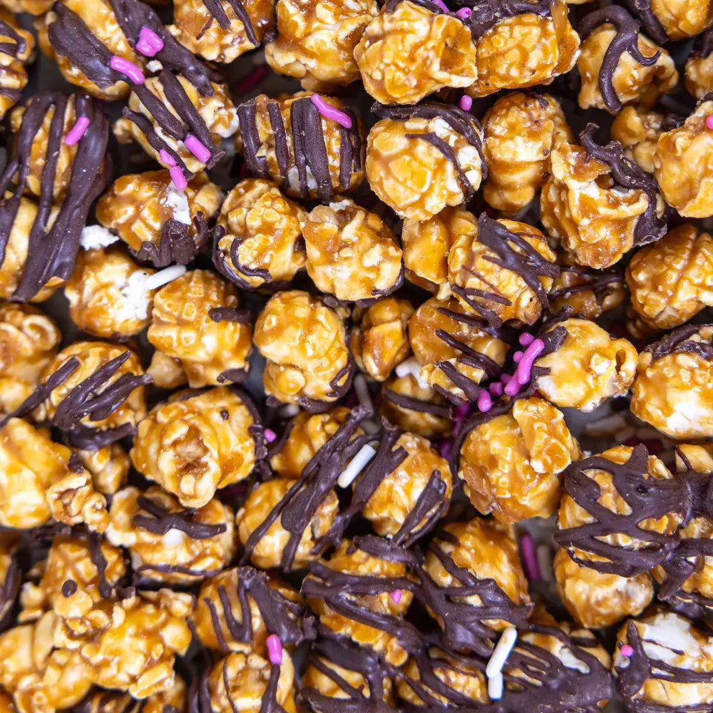 Cupid's Confetti popcorn with caramel, chocolate drizzle, and colorful sprinkles for a festive treat