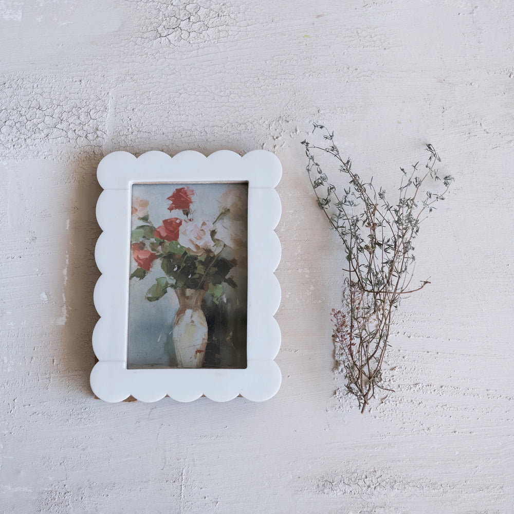 Scalloped resin photo frame in white showcasing a floral painting with delicate vase design