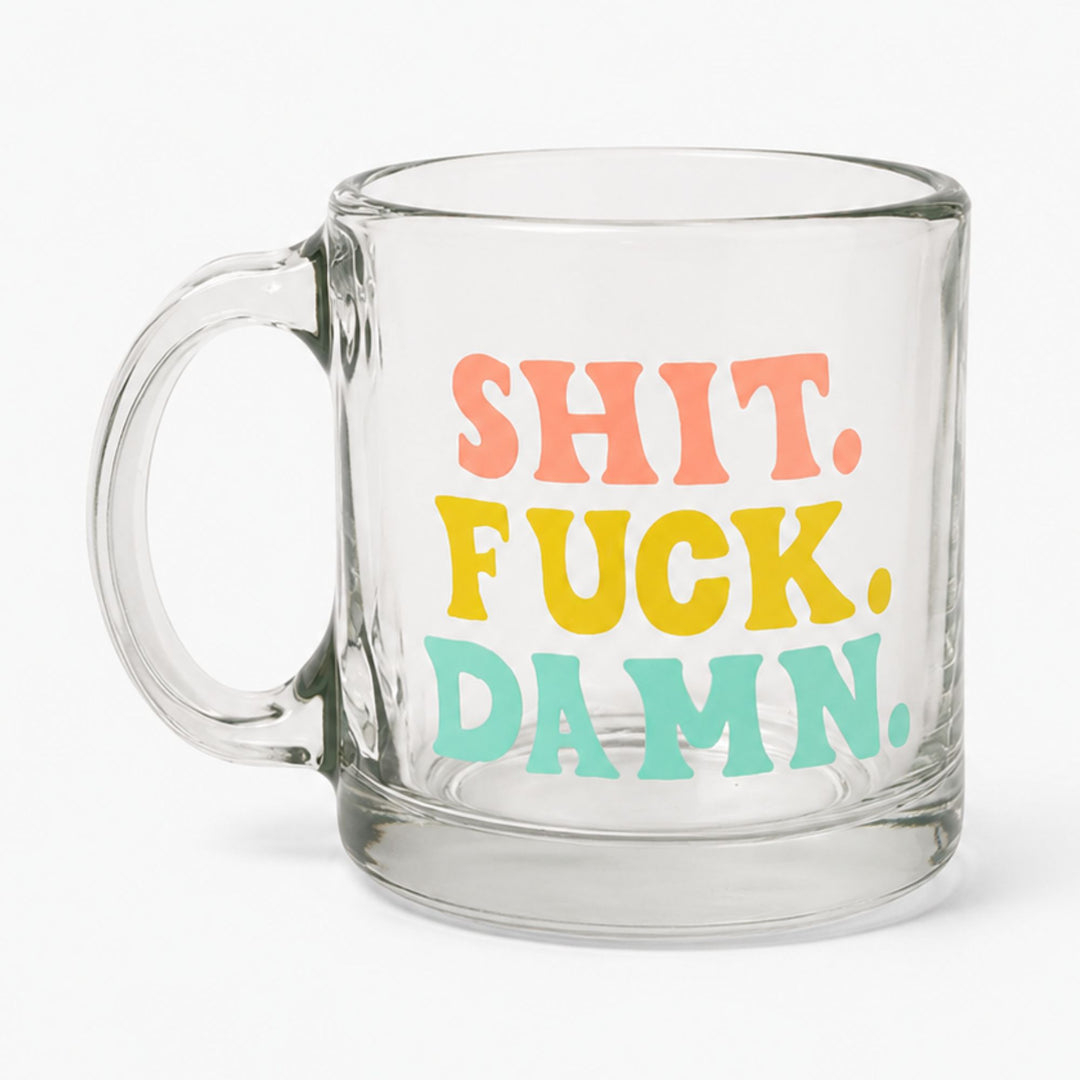 A clear glass mug with a handle, featuring the text 'SHIT. FUCK.