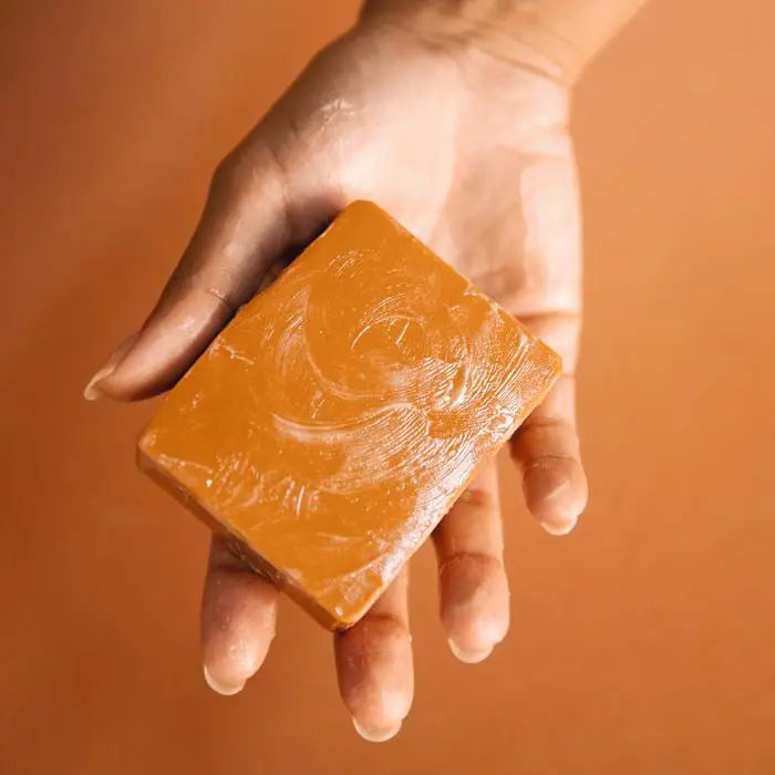 Slow North Moonglow Natural Bar Soap held in a hand with a warm background