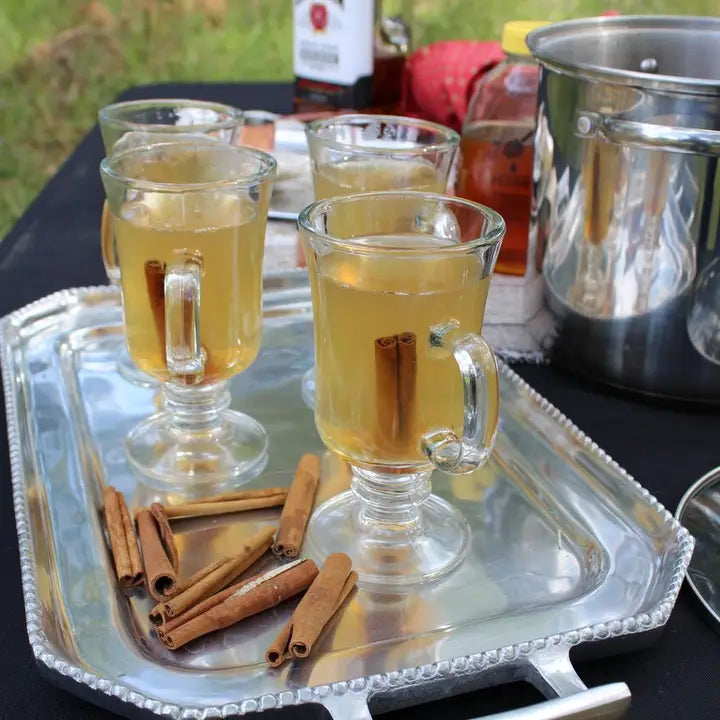 Oliver Pluff Spiced Tea served in glass mugs with cinnamon sticks on a silver tray