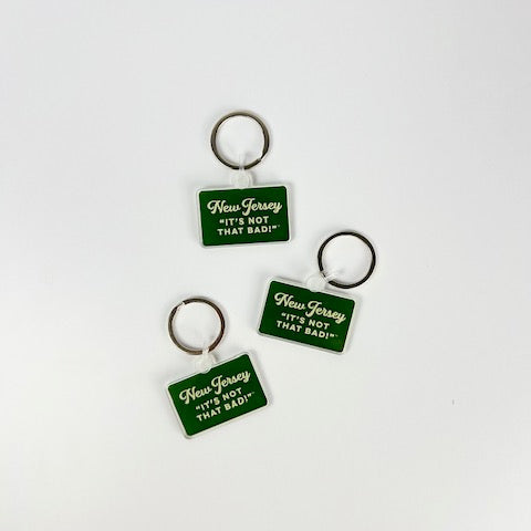 Acme New Jersey keychain with green rectangular tag and white text reading It’s not that bad