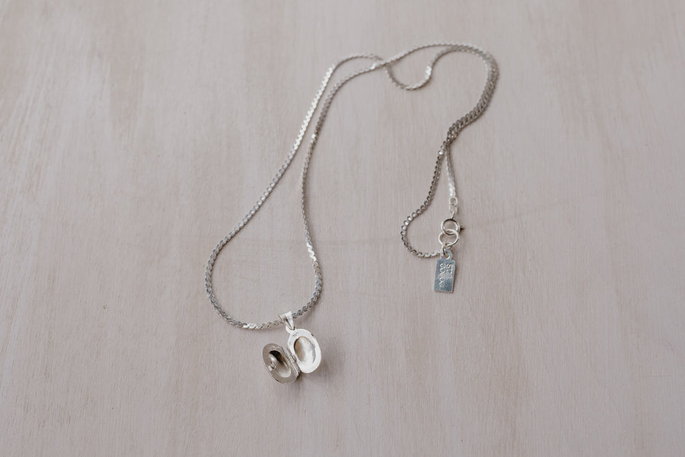 silver chain with an opened silver oval shaped locket