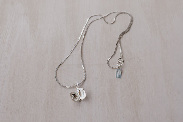 silver chain with an opened silver oval shaped locket
