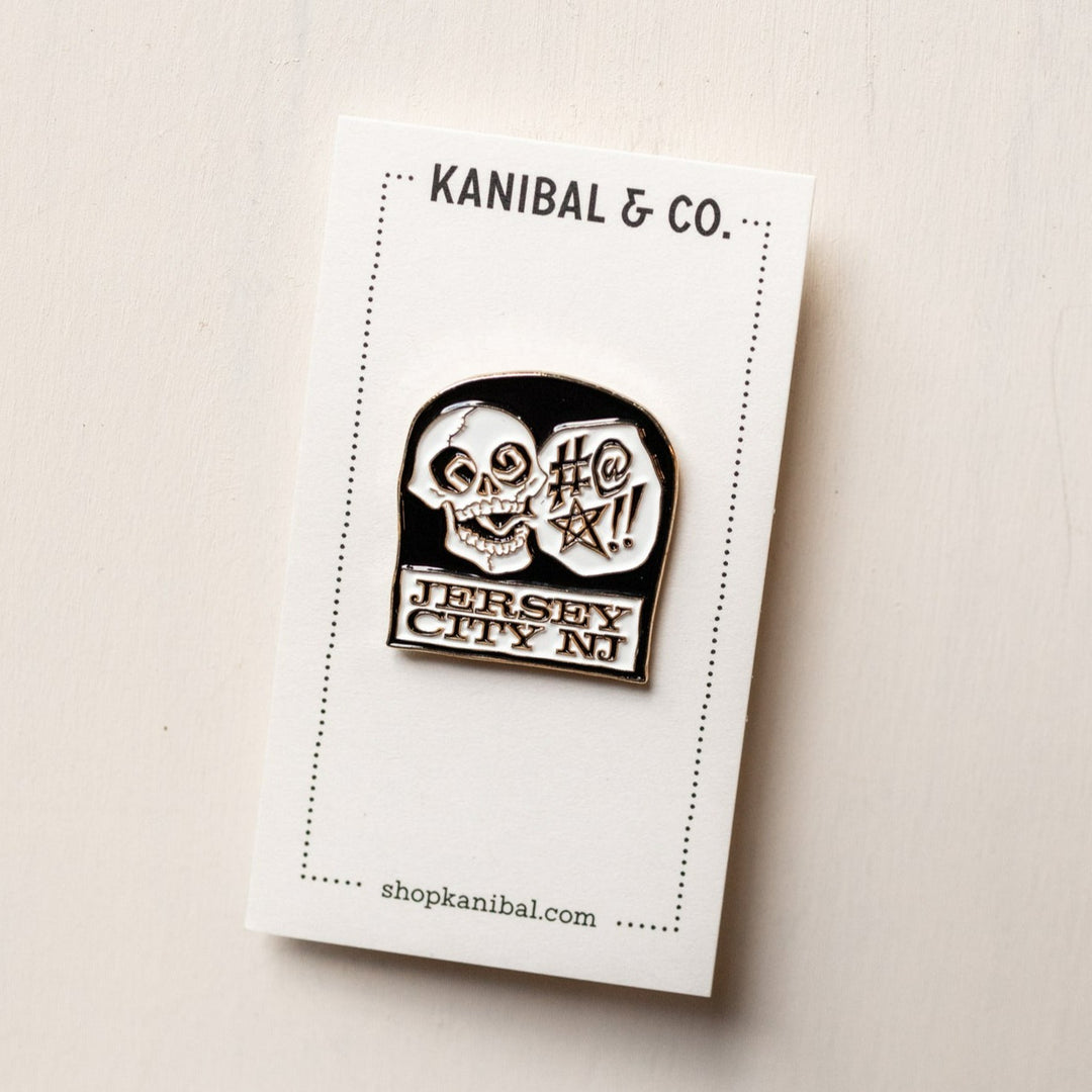 black and white pin with skull on headstone on cardstock