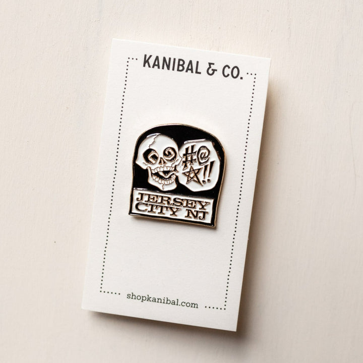 black and white pin with skull on headstone on cardstock