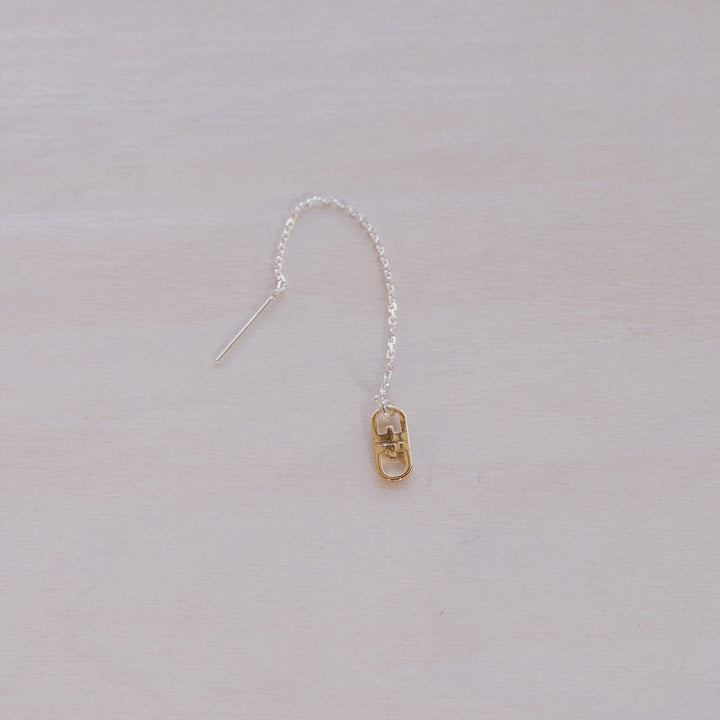 single earring with silver chain and gold charm