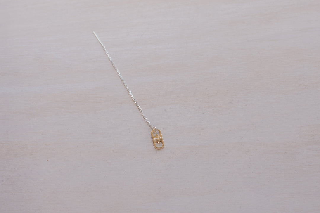 single earring with silver chain and gold charm