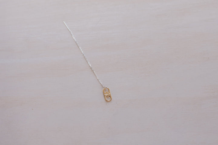 single earring with silver chain and gold charm