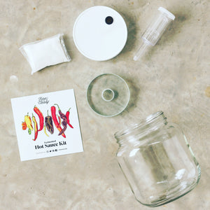 glass jar and tools needed, card illustration of peppers, and packet of ingredients