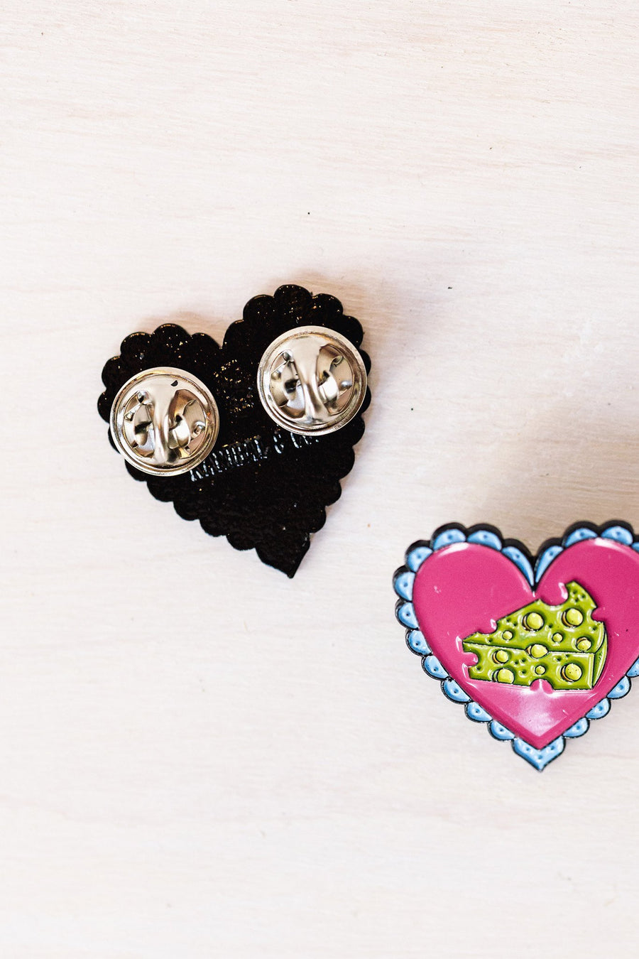 2 pins, one frontside and one backside showing silver pin backings