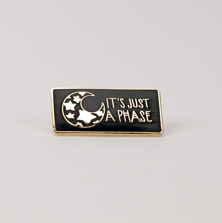 black and gold rectangle pin with illustration of mood with stars inside it.