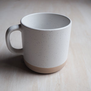 Backside of the mug is the same two toned colorway: tan & white with black specks