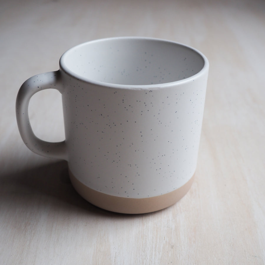 Backside of the mug is the same two toned colorway: tan & white with black specks