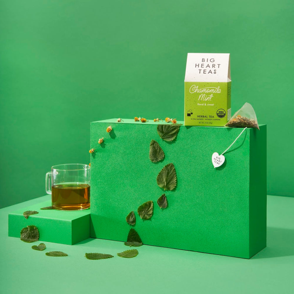 Big Heart Tea Co chamomile mint herbal tea box with tea bag and glass cup on green display