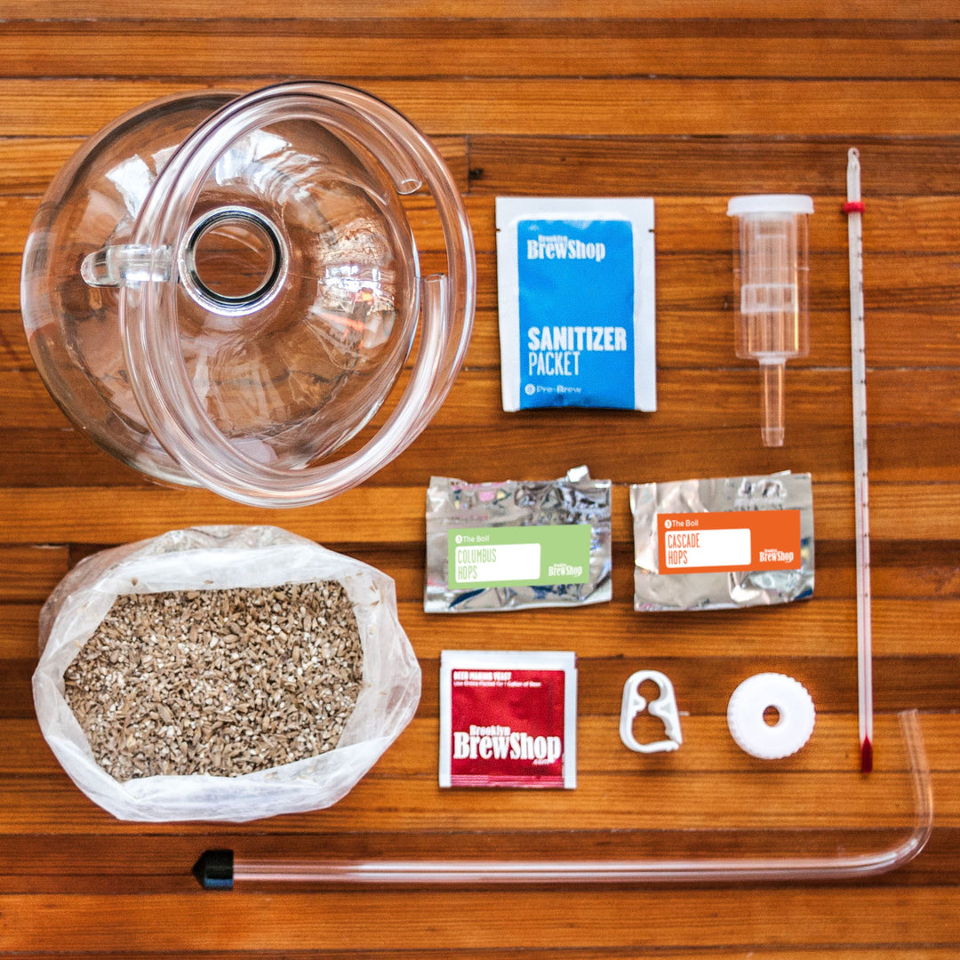 DIY IPA beer making kit by Farm Steady Brooklyn Brew Shop with brewing ingredients and equipment on wooden table