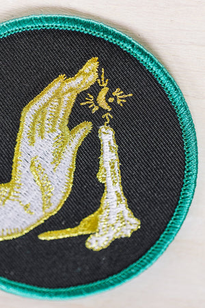 Kanibal & Co candlelight embroidered patch with hand and candle design on black fabric