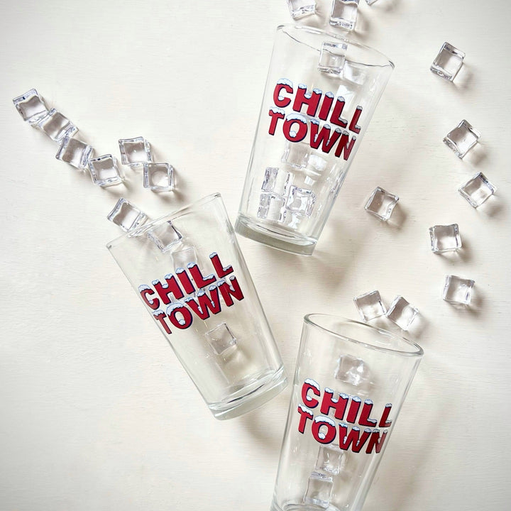 Kanibal & Co glassware featuring three Chill Town pint glass with scattered ice cubes on white background
