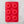 A red rectangular baking pan with 6 round indentations for donuts