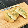 Garlic herb focaccia baking kit bread freshly baked and sliced on wooden cutting board with knife