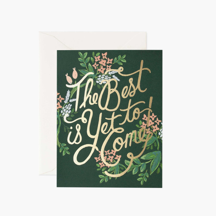 Rectangular card on a forest green background that reads "The best is yet to come!" with a floral design around the letters