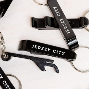 Black Jersey City bottle opener keychain with white text on a metal key ring by Kanibal Co.